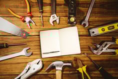 Notebook and pen against tools on desk-1